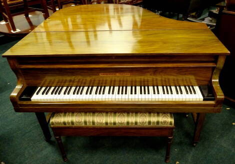 A walnut and simulated walnut baby grand piano by Ascherberg Perzina, on square tapering legs, 154cm W, and a rectangular duet piano stool, with a hinged padded seat on turned leaf carved tapering legs, 93cm W.