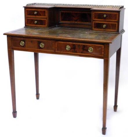 An Edwardian and mahogany satinwood crossbanded desk, the raised back with a three quarter pierced brass gallery, above four small drawers, the top with a brown leather inset above two frieze drawers, on square tapering legs, 91cm W.