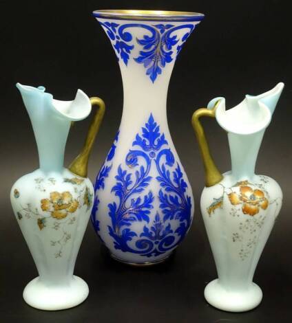 A blue glass overlay vase in Bohemian styles, and a pair of Victorian glass ewers. (3)