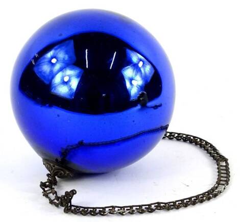 A 19thC blue glass witches ball or bauble, with section of chain, 16cm diameter.