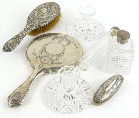 Various dressing table items, to include a cut glass slender jar and cover with silver lid, a silver backed hand mirror, a silver backed brush, a square section scent bottle with cut decoration and a pair of cut glass candlesticks, and a nail buffer.