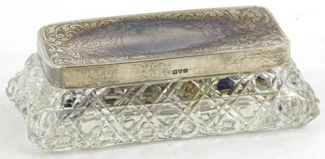 A rectangular cut glass and silver mounted hair pin tidy or dressing table box, with engraved decoration surrounding a vacant cartouche, Chester 1913, George V.