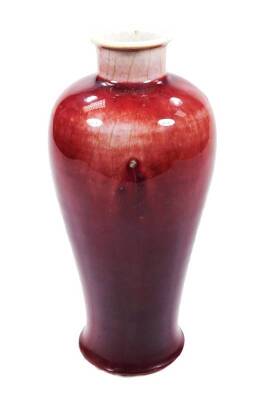 A Chinese porcelain sang de boeuf vase, with compressed stem, shouldered body and circular foot, unmarked, 25cm H.