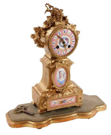 A 19thC French gilt metal mantel clock, with 8cm Dia. Sevres style porcelain dial with Roman numerals, above a further two panels of a lady and musical instruments and scrolls, in a heavily cast case surmounted by leaves, berries and ewer, with 8-day move