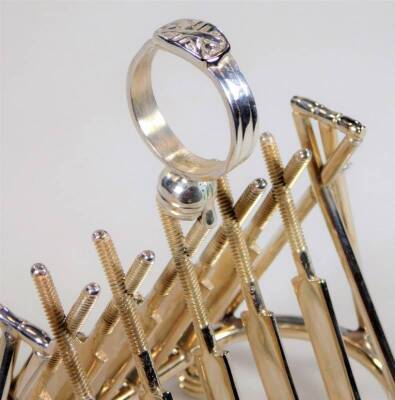 A 20thC silver plated cricket related toast rack, with stump ends and fixed sectional bat centre, centred by a ring and ball top, on compressed orb feet, 17cm H. - 2