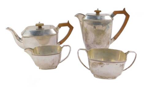 A George VI silver four piece tea set, of oblong footed form, comprising teapot, hot water jug, cream jug and sugar bowl, Sheffield 1945, 57.14oz.