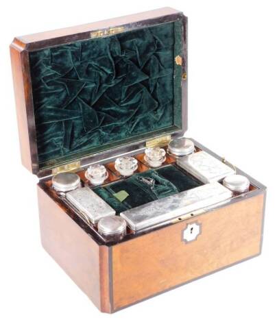 A Victorian walnut cased travel box, the shaped rectangular body centred by a mother of pearl cartouche, with ebonised outline and fitted interior, containing a number of various jars, bottles, etc., some with plated lids, with a green velvet lining and s