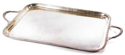 An Edwardian silver tray, by James Dixon & Son, of rectangular outline, partially gadrooned with shaped handles, Sheffield 1904, 127oz, 71cm W.