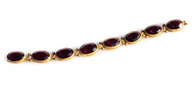 A Georgian garnet set bracelet, with eight oval stones, in gilt metal settings, possibly some missing (AF), the current bracelet 16.5cm L.