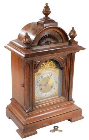 A late 19thC oak bracket clock, the arched 15cm dial with silvered Arabic chapter ring, in a heavily carved domed case flanked by quarter columns on compressed feet, revealing an hour striking 8-day movement, 58cm H.