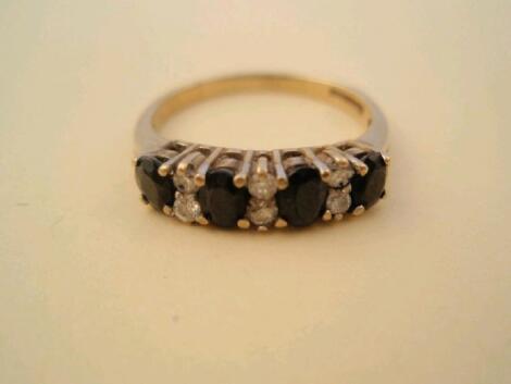 A 9ct gold dark blue stone and diamond half hoop ring