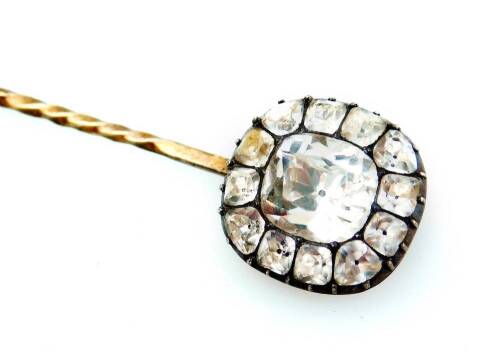 A Victorian stick pin, set to the top with white paste stones, with larger stone to centre surrounded by twelve smaller stones, in silvered colour claw setting, on a yellow metal pin, unmarked, 2.2g all in, the pin head 14mm H.