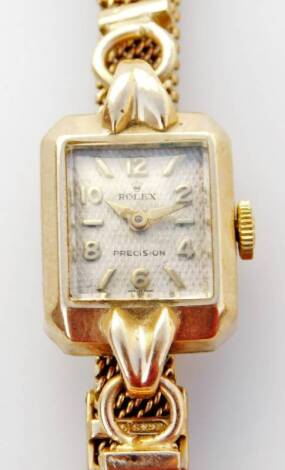 A ladies Rolex cocktail watch, with square silvered dial, bezel wind stamped with Rolex symbol, on a weave design bracelet, marked 9ct, 13.4g.