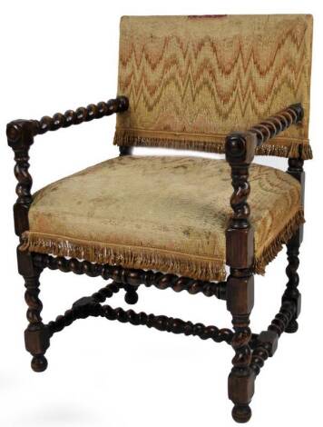 A 19thC hand carved Jacobean style armchair, with overstuffed back and seat, barleytwist arms and turned forelegs on orb feet, 81cm H.