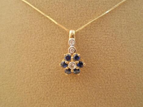 A pendant as a flower set with tiny diamonds and sapphires on a fine chain