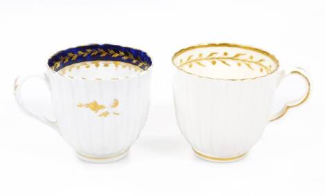Two Caughley polychrome fluted coffee cups, c.1780, one decorated with a internal gilt band of foliage, the other with a blue band and gilt foliage, unmarked, 6cm H. (2)