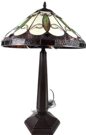 An as new table lamp, with Tiffany style shade, with repeat pattern scroll design predominately in green, purple and cream, 70cm H.