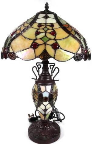 An as new table lamp, with Tiffany style shade and stem, in floral pattern predominately in cream, green and red, 63cm H.