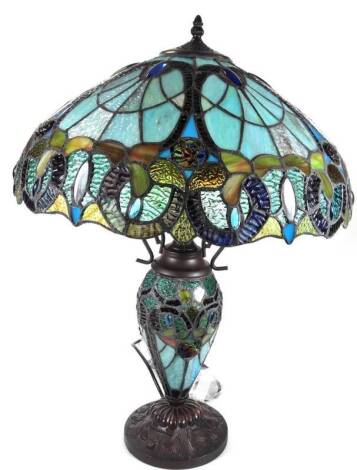 An as new table lamp, with Tiffany style shade, set with a repeat floral pattern predominately in blue, orange and green, 66cm H.