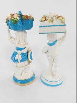 Two late 19thC Brownfield porcelain figures of a girl and boy, each modelled standing, the girl holding a folded cloth of flowers on her head, the boy holding a basket containing a folded cloth of strawberries and a bird on his head, raised on circular ba - 3