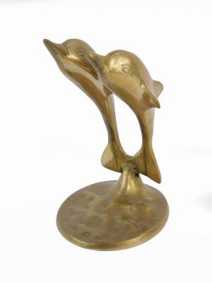 A Brass sculpture modelled as a pair of dolphins, modelled on an oval base, 14cm H.