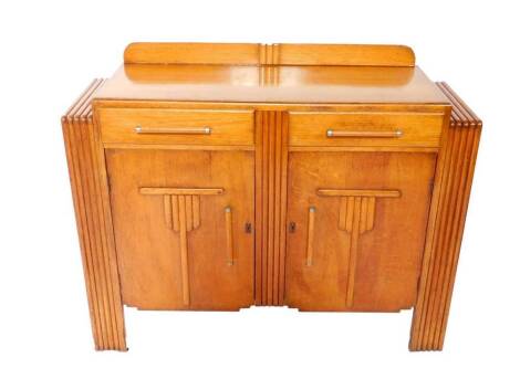 A mid 20thC Art Deco style oak sideboard, with two drawers above carved panel doors, flanked by two side cupboards, raised on fluted straight supports, with key, together with plate glass top, 97cm H, 120cm W, 41cm D.