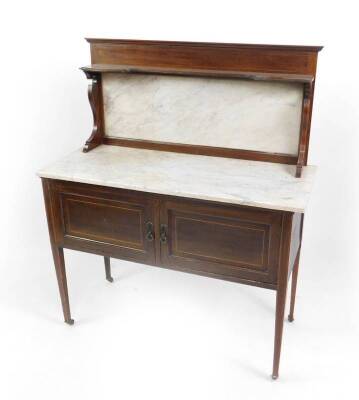 A Victorian mahogany and white marble topped washstand, the white marble splash back beneath a shaped shelf with boxwood line inlay, over a pair of cupboard doors, raised on tapering square legs, capped on castors, 129cm H, 107cm W, 45cm D.