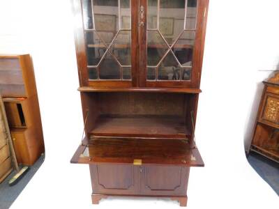 A Georgian style mahogany cupboard bookcase, the outswept pediment over two astragal glazed doors enclosing two shelves, over a drop flap drinks cabinet over two cupboard doors, raised on bracket feet, 236cm H, 101cm W, 50cm D. - 2