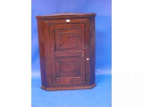 A Georgian oak hanging corner cupboard with double panel door and later