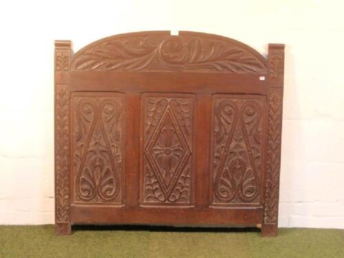 An oak bed head or panel with period carving