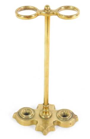 A Victorian Gothic brass twin division umbrella stand, patent No. 6332, on a cast iron loaded base, 32.5cm H.