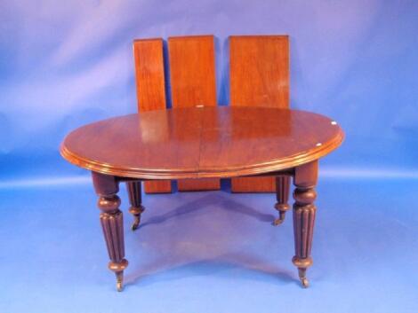 A Victorian mahogany extending dining table with moulded oval top and wind-out