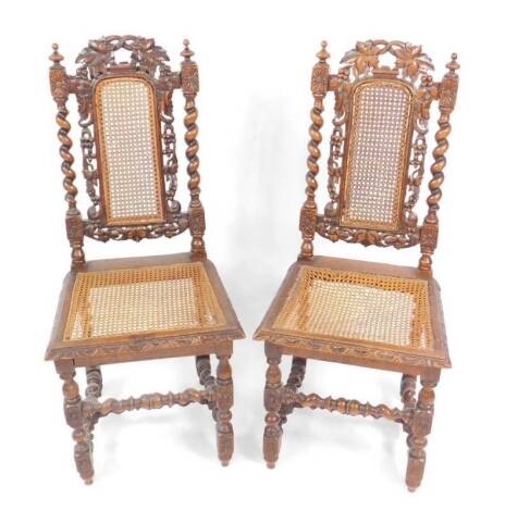 A pair of Victorian oak single dining chairs, with vine carved framed cane backs, and spiral twist supports, cane seat, raised on turned legs united by turned stretchers, each 109cm H, 47cm W, 49cm D.