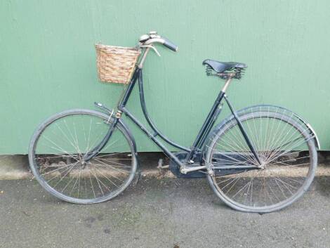 A lady's black framed vintage bicycle, with a Wilby black leather seat.