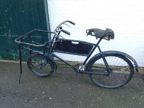 A vintage black framed grocer's bicycle.