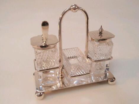 An early 20thC plated condiment set with cut glass cruets on ball feet