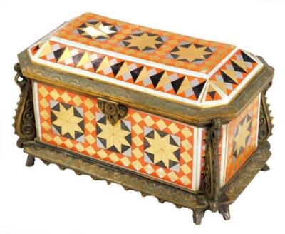 A 19thC gilt metal and polished glass casket, possibly Russian, sarcophagus form, decorated with a repeat star and diamond pattern in black silver, orange and gilt, with velvet lined interior, with elaborate escutcheon on bark feet, 15cm H, 22cm W, 14cm D