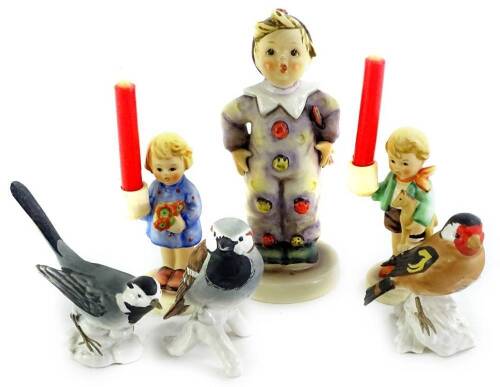 A collection of Goebel figures, to include a Hummel figure of a boy, dressed as a clown, a pair of candlesticks and three Goebel birds.