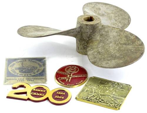 A narrow boat brass propeller and four plaques relating to canals.