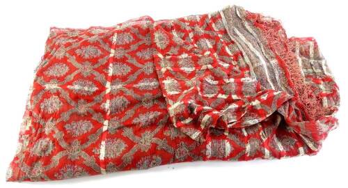 An Indian silk shawl, with designs of flowers within stylised lozenge shaped cells, on a red ground. (AF)