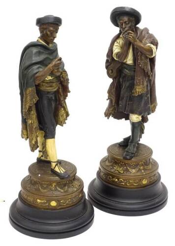 A pair of continental spelter figures, each modelled in the form of a musician smoking, and another gentleman pouring a drink, on a tapering base, cast with musical trophies, swags etc., and ebonised plinth, 68cm H and 70cm H respectively.