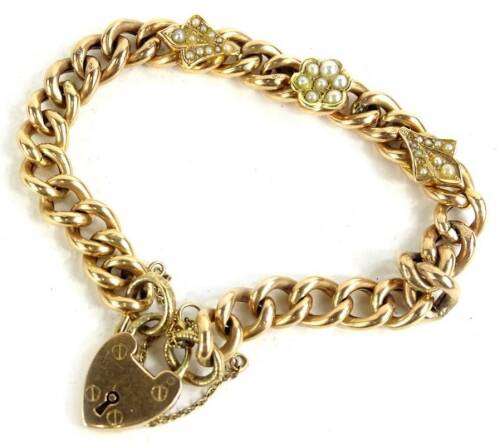 A Victorian curb link bracelet, with three seed pearl set motifs, central flower, and two leaves, with curb links, some marked 9C, on a heart shape padlock, marked 15ct, 19.2g all in.