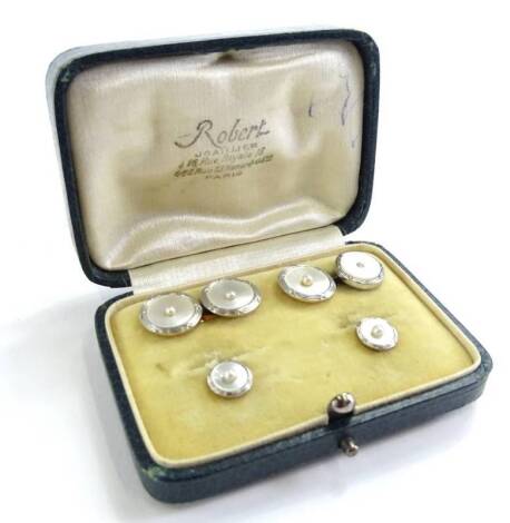 A cased set of mother of pearl tie and collar studs, comprising two collar studs, and a pair of cufflink's, each with mother of pearl front set with tiny seed pearl, on white metal surround, on gold backing, in fitted case, marked Robert Paris.