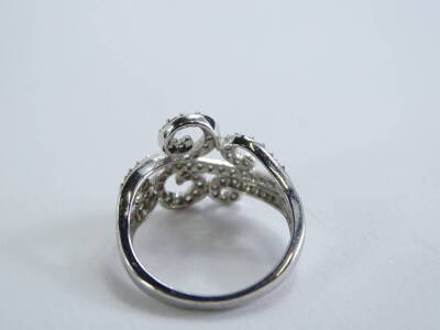 A 9ct white gold dress ring, with scroll design, set with imitation diamonds, ring size N, 3.3g all in. - 2