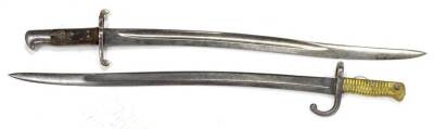 Two French Bayonets, each with a shaped blade, brass or steel handle, dated 1879-1.