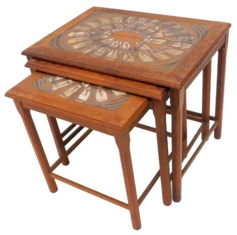 A 1970s Danish teak nest of tables, each with a tile panel inset to the top on chamfered legs, 56cm W.