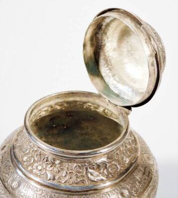 An early 20thC Indian white metal jar and cover, of bellied form, heavily repousée decorated with panels, scrolls and flowerheads, with an upper bird and floral pattern, on a circular foot, 12cm H. - 4