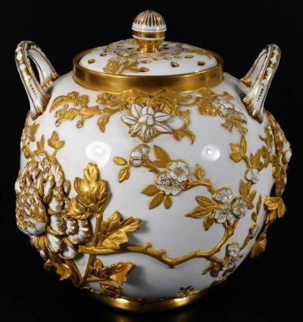 A late 19thC Coalport potpourri vase and cover, of large proportion, the globular body flanked by two handles and raised with various petals and flowerheads, with gilt highlights and a partially pierced lid, on a circular foot, green crown mark beneath, 2