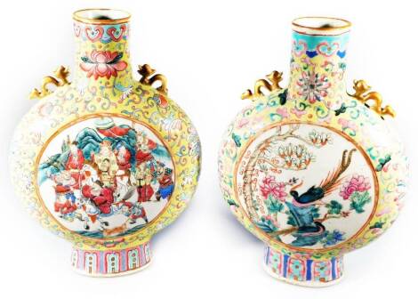 A pair of 19thC Chinese famille jaune porcelain moon flasks, each with compressed cylindrical stems flanked by dragon handles, the circular bodies decorated with panels of birds and figures predominately in yellow, pink, blue, green and orange, on oval fe