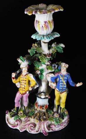 An 18thC unrecorded Bow porcelain candlestick figure group, of two Cossack officers standing around a cooking pot, on a C scroll base, c1765, 23cm H. Note Bradshaw records these figures as single figures.